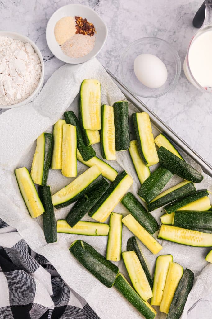 zucchini sticks laid out on paper towel.