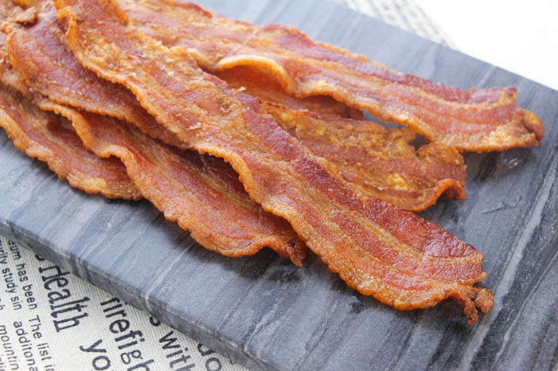 stack of crispy bacon on a grey plate