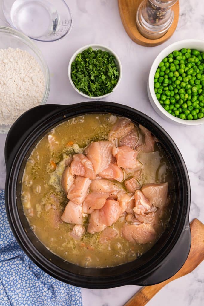 chicken being added to dutch oven. 