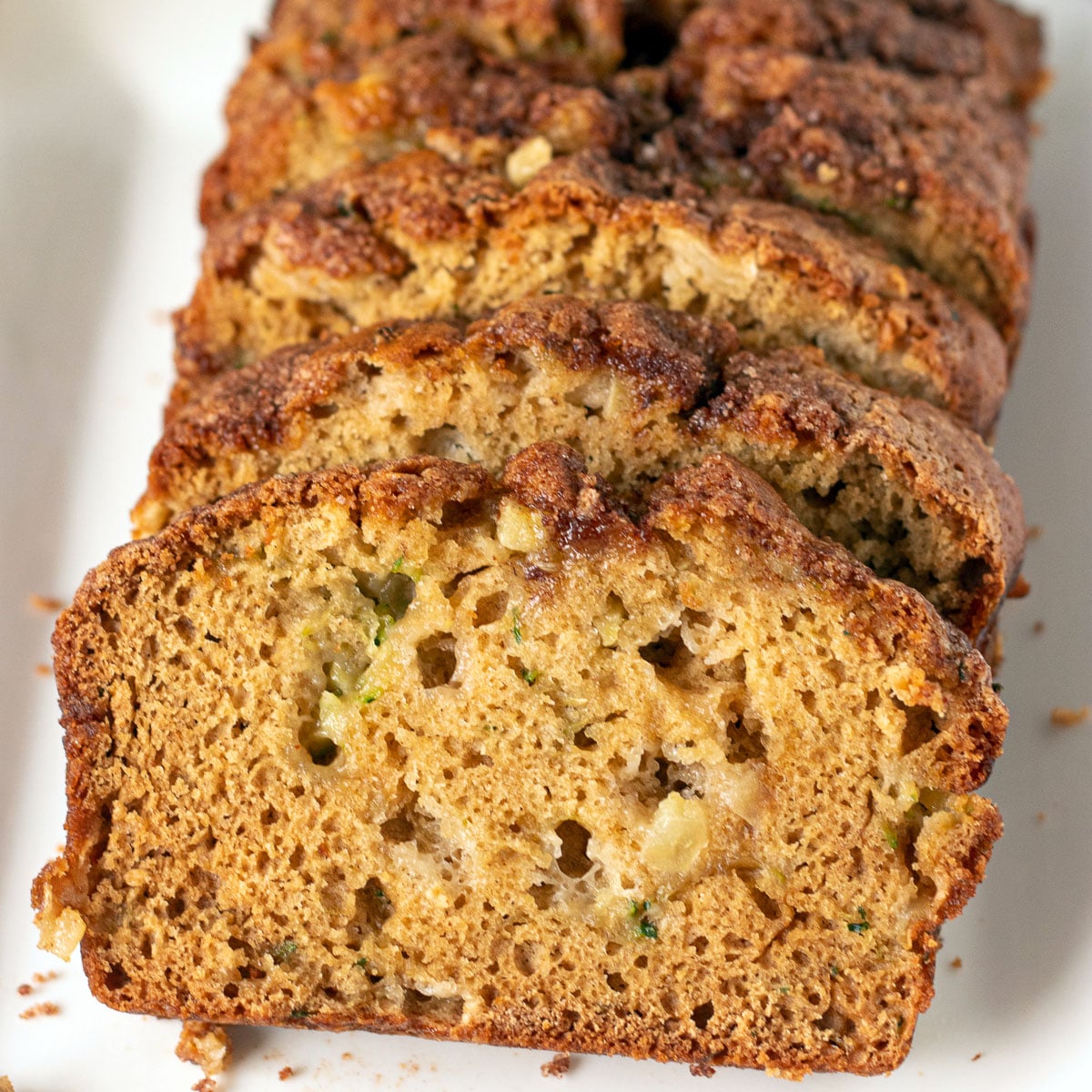 sliced apple zucchini quick bread on white plate