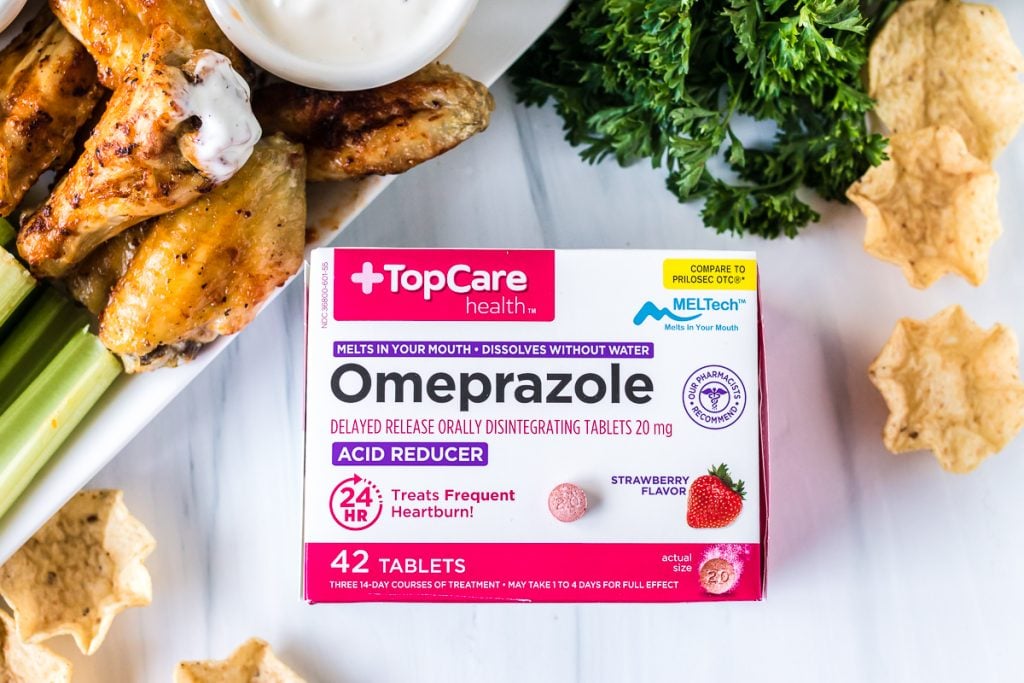 box of omeprazole tablets next to chicken wing platter