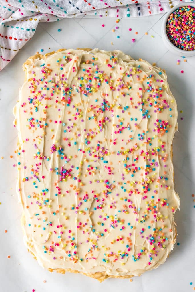 overhead shot of a batch of sugar cookie bars with sprinkles before being cut.