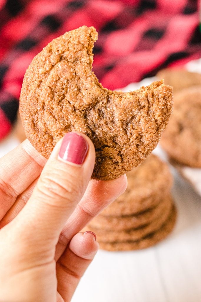 hand holding a cookie with a bite taken out of it
