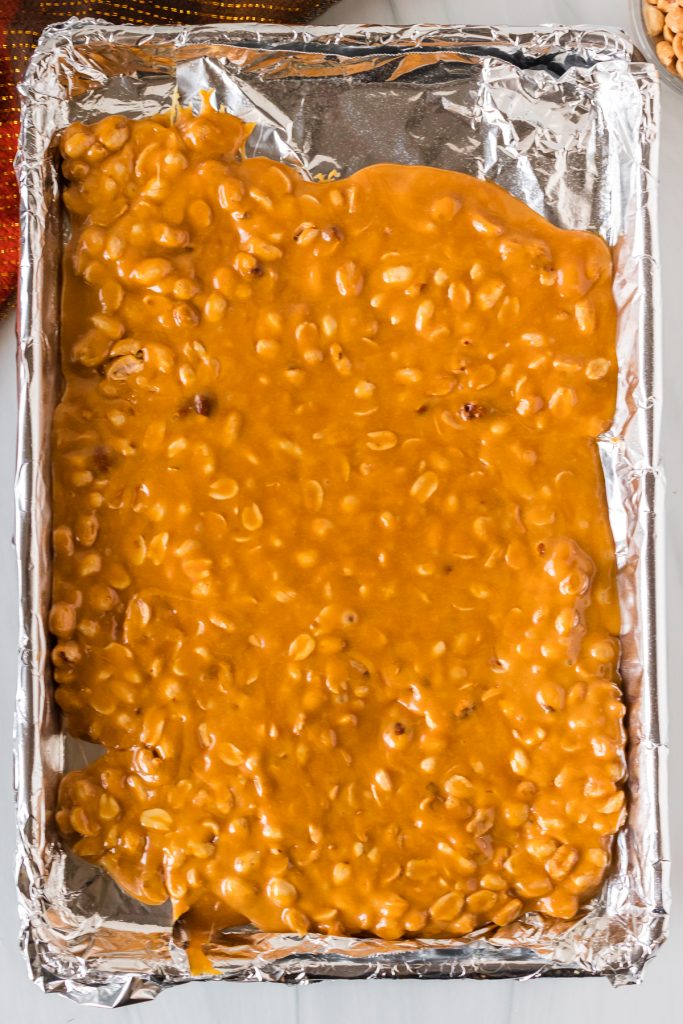peanut brittle poured onto a baking sheet