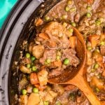 closeup of spoon scooping out slow cooker beef stew from a crockpot