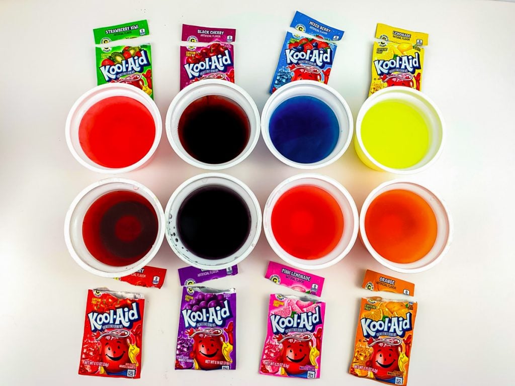 kool-aid packets next to corresponding cups of colored water