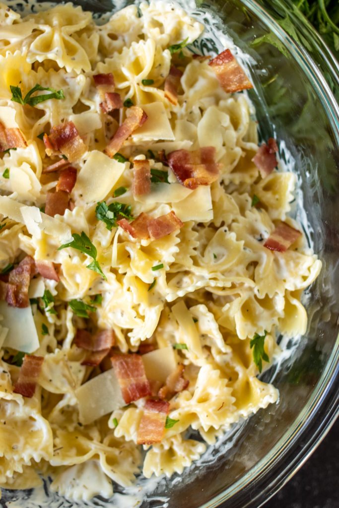 overhead shot of creamy bow tie pasta in a glass bowl