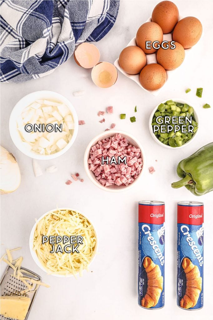 labeled ingredients laid out for making a breakfast pizza with crescent roll dough