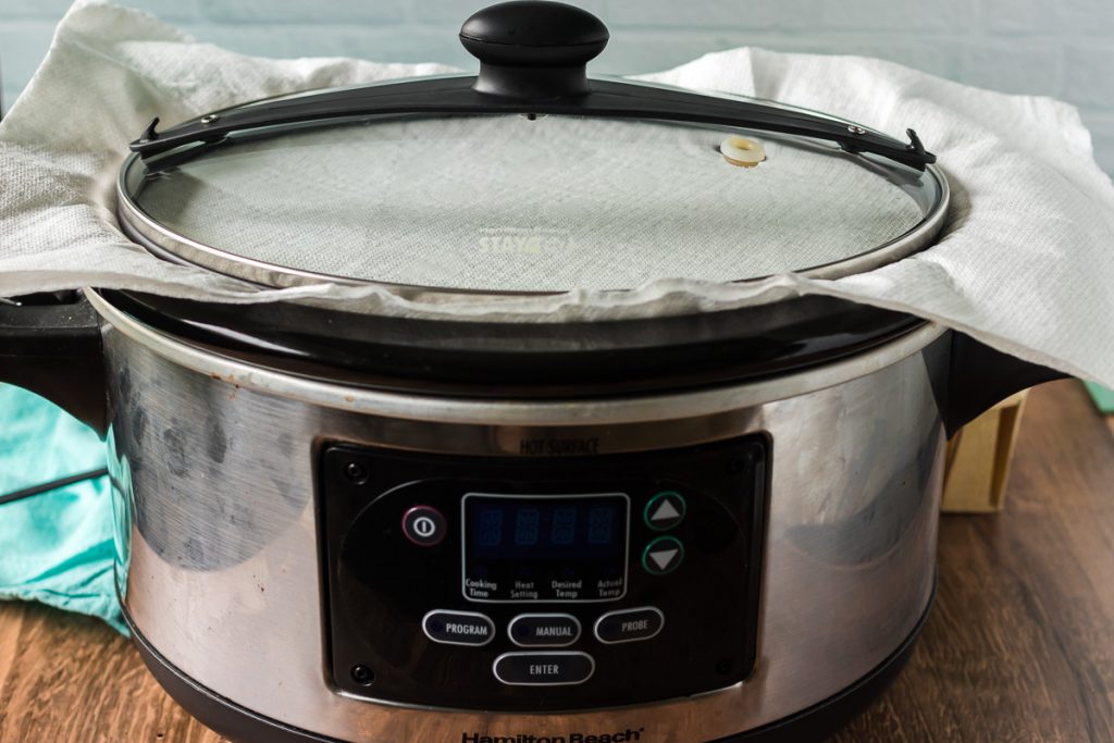 slow cooker with paper towel under lid to catch condensation