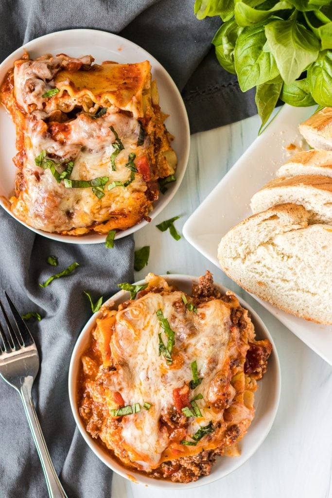 overhead shot of plates of lasagna with sliced bread