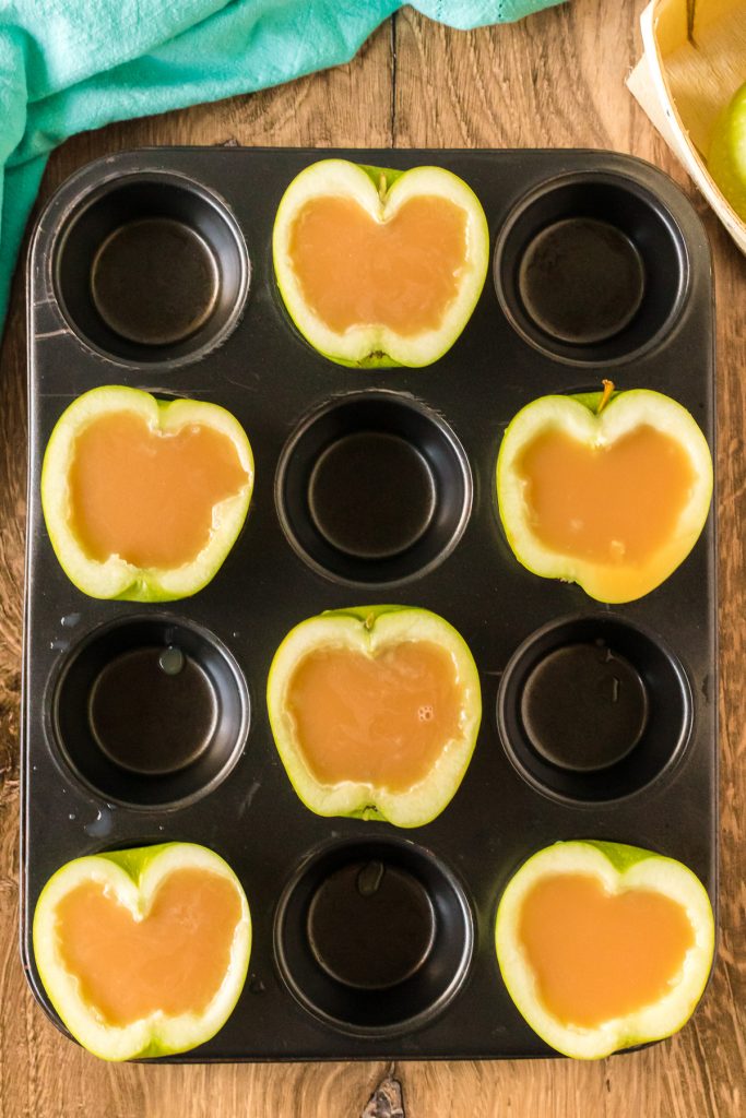 overhead shot of sliced apples in a muffin tin filled with caramel