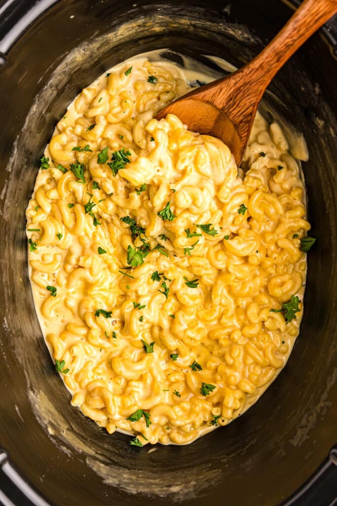overhead shot of slow cooker mac & cheese in black crockpot.