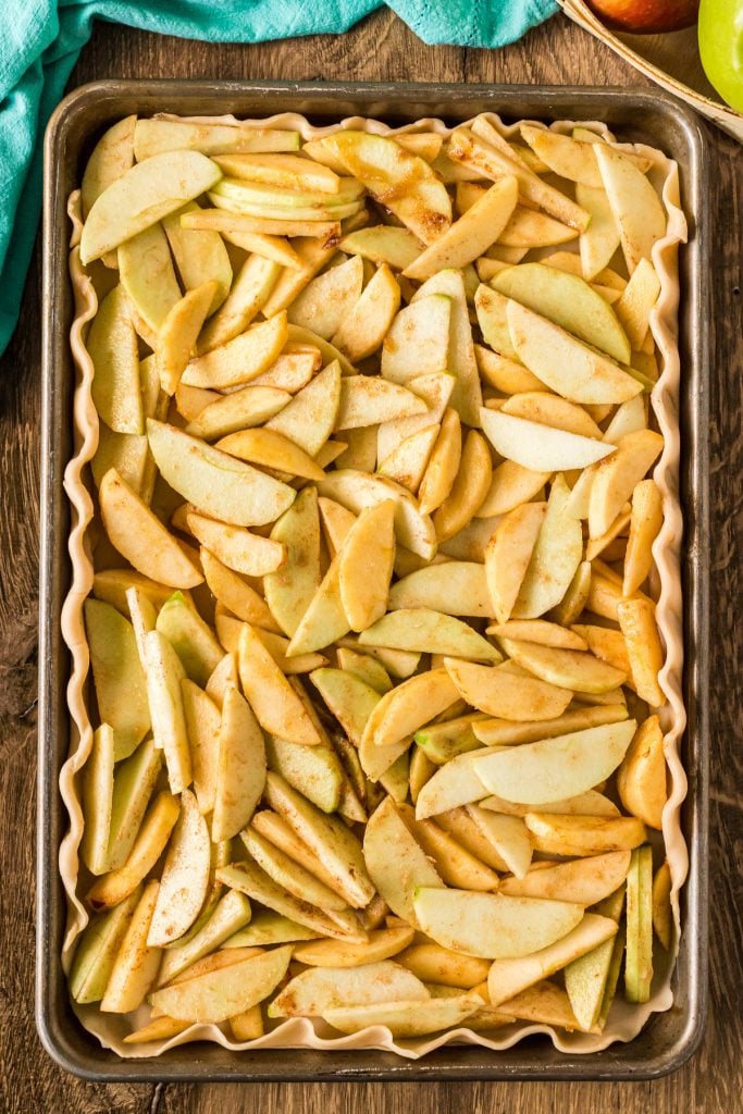 overhead shot of apples in a pie crust in a baking sheet