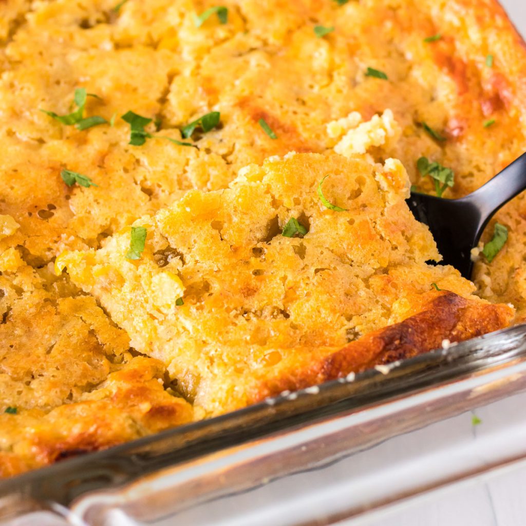 green chile corn casserole being lifted from a baking dish