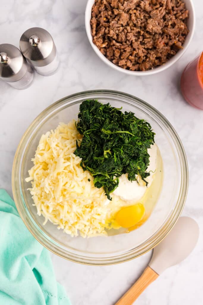 spinach, cheese, and egg in a mixing bowl.