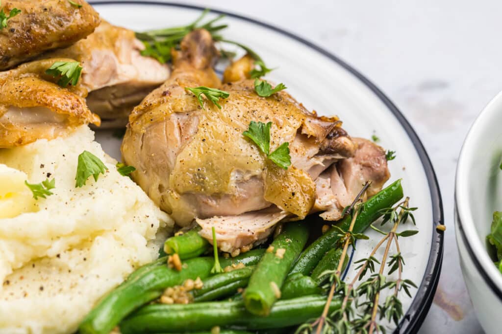 Close-up of chicken, mashed potatoes, and green beans.