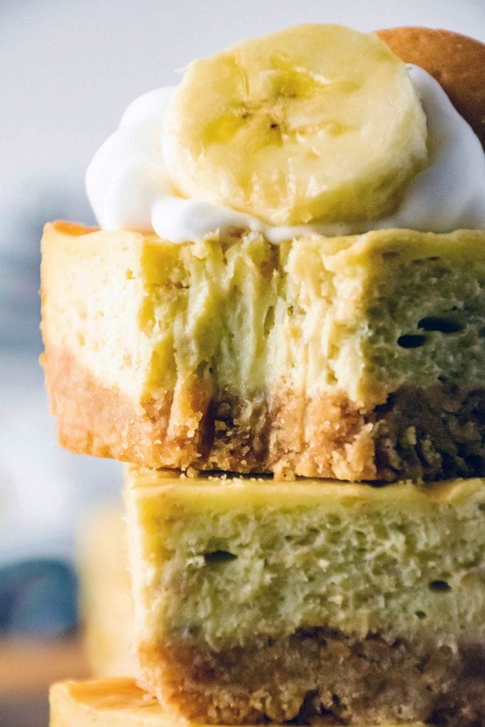 closeup of a bite taken out of a banana pudding cheesecake bar.