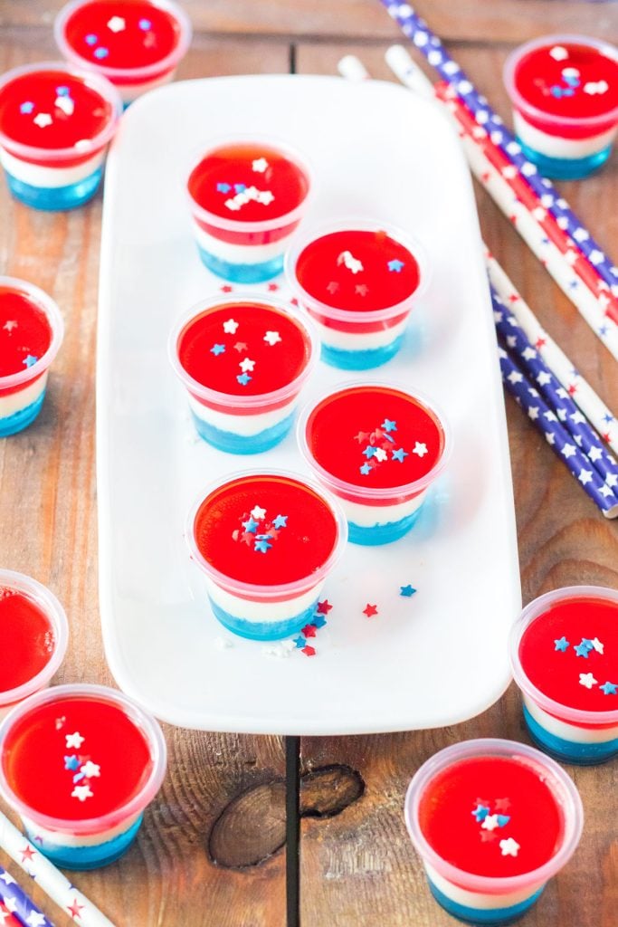 layered american flag jello shots on a white platter.