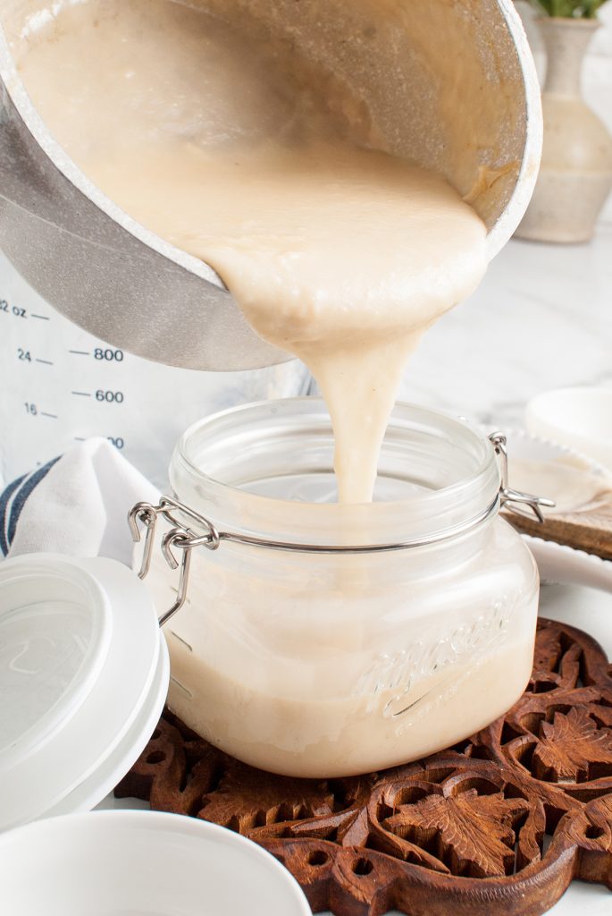 cream of chicken soup pouring into a glass jar.
