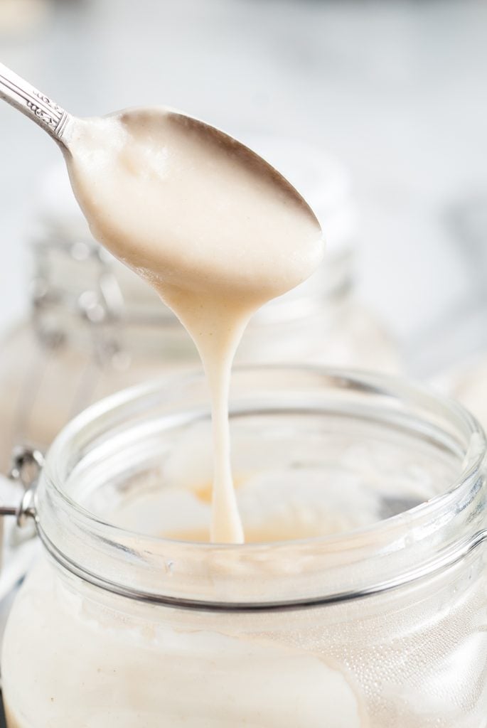 spoon dripping into cream of chicken soup in an airtight canister.