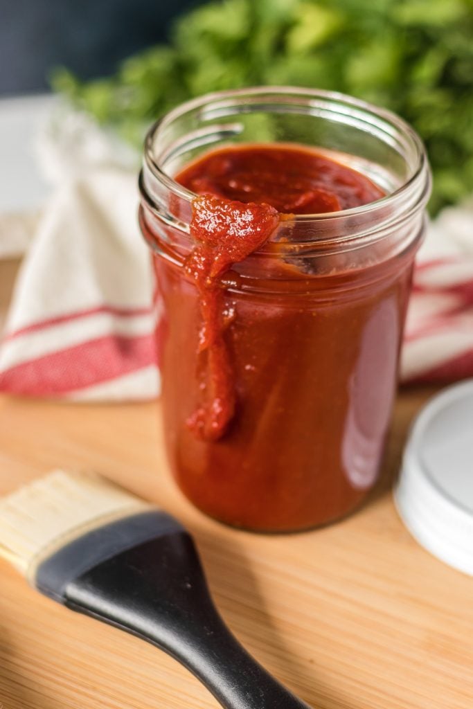 mason jar of kfc honey bbq sauce with basting brush.