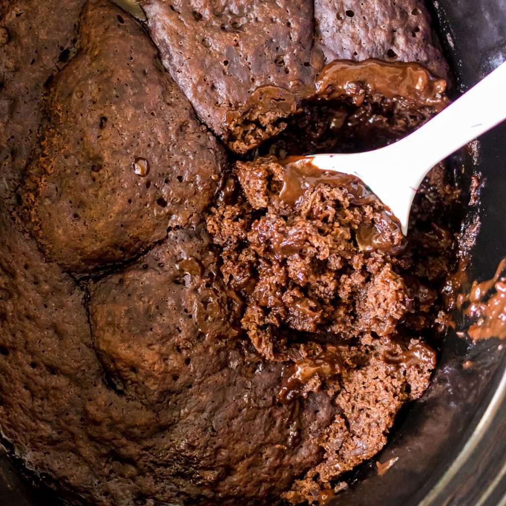 spoon scooping lava cake from a crockpot.