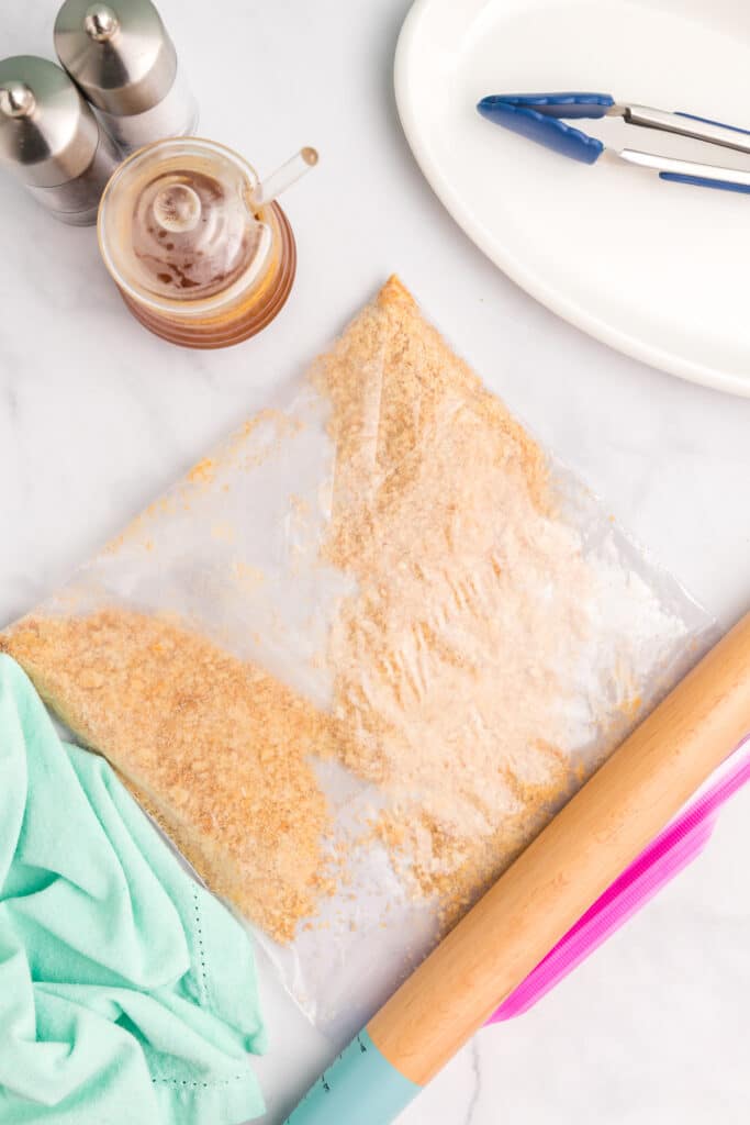 rolling pin smashing crackers in a zip top bag.