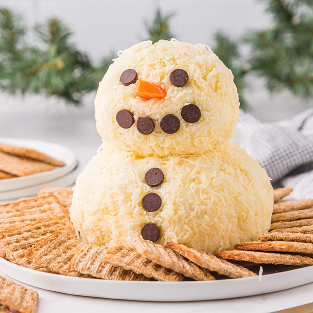 snowman cheeseball surrounded by crackers.