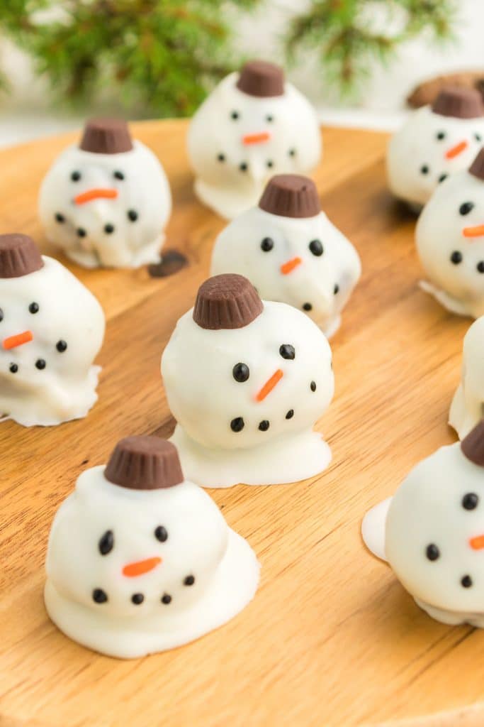 snowman oreo truffles on a wood board.