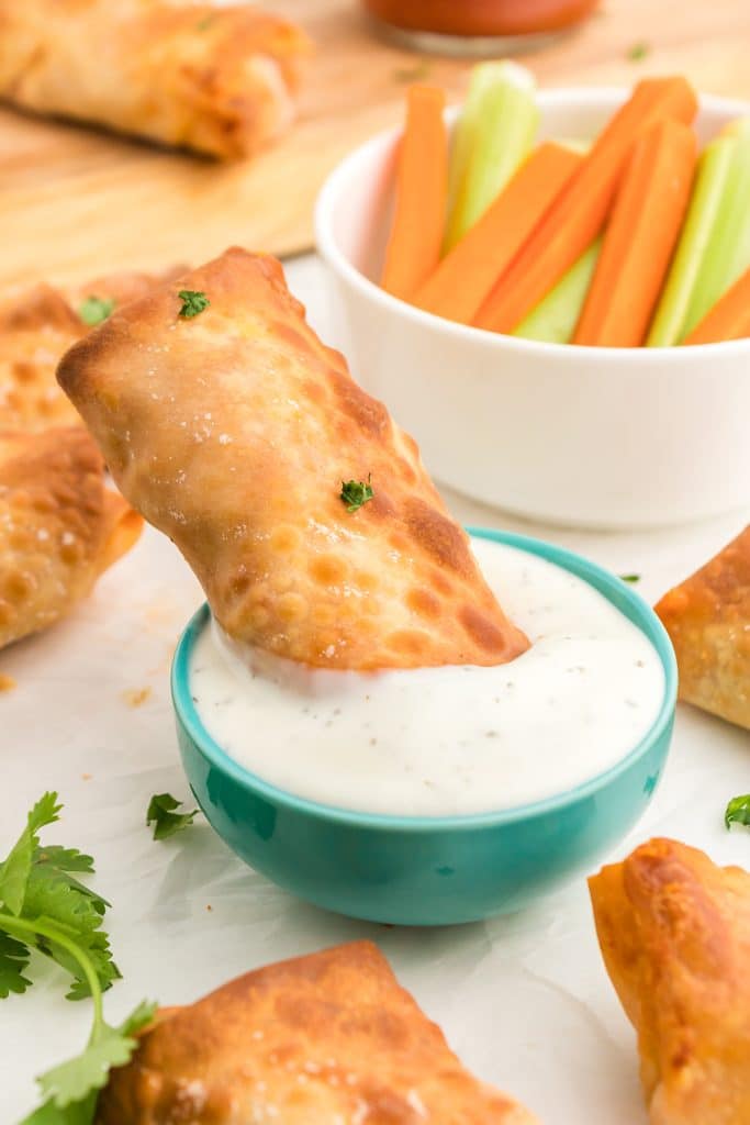 buffalo chicken egg roll dipping into ranch dressing.
