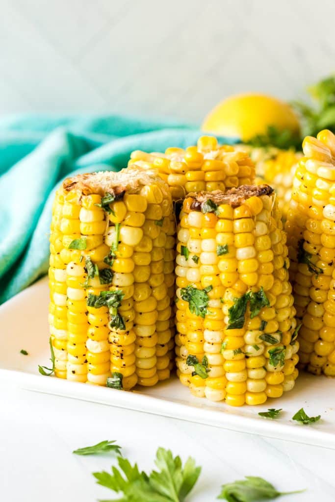corn on the cob pieces standing up on a white plate.
