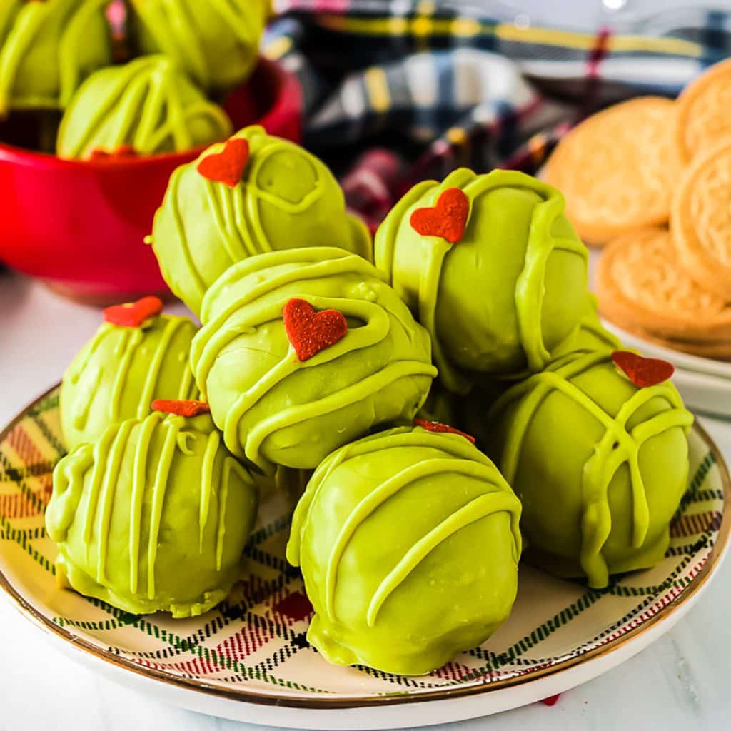 plate of green grinch oreo balls with a heart shaped sprinkle.