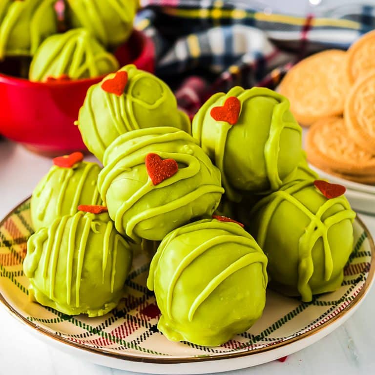 plate of green grinch oreo balls with a heart shaped sprinkle.