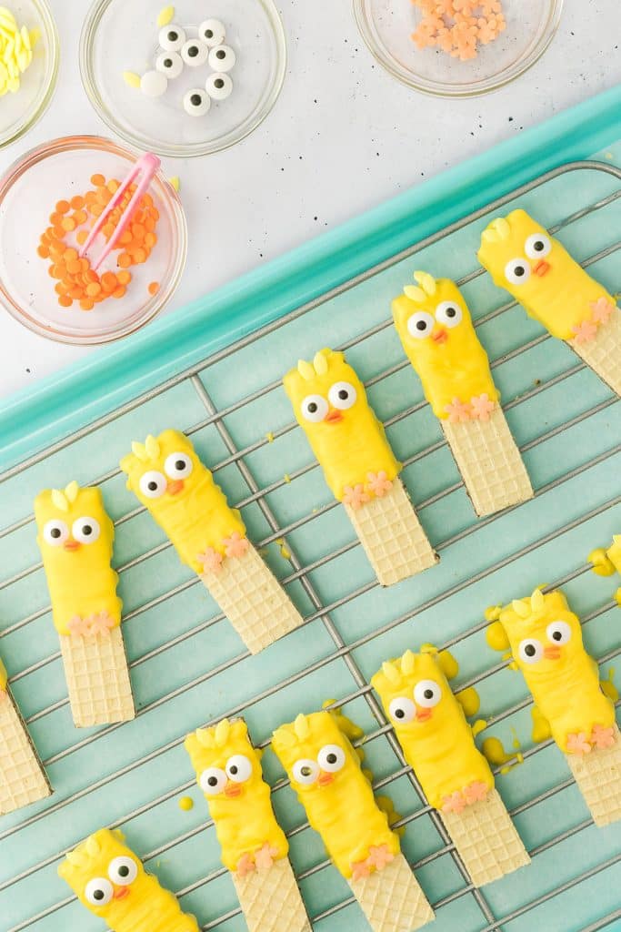 overhead shot of easter decorated dipped sugar wafer cookies on a wire rack.