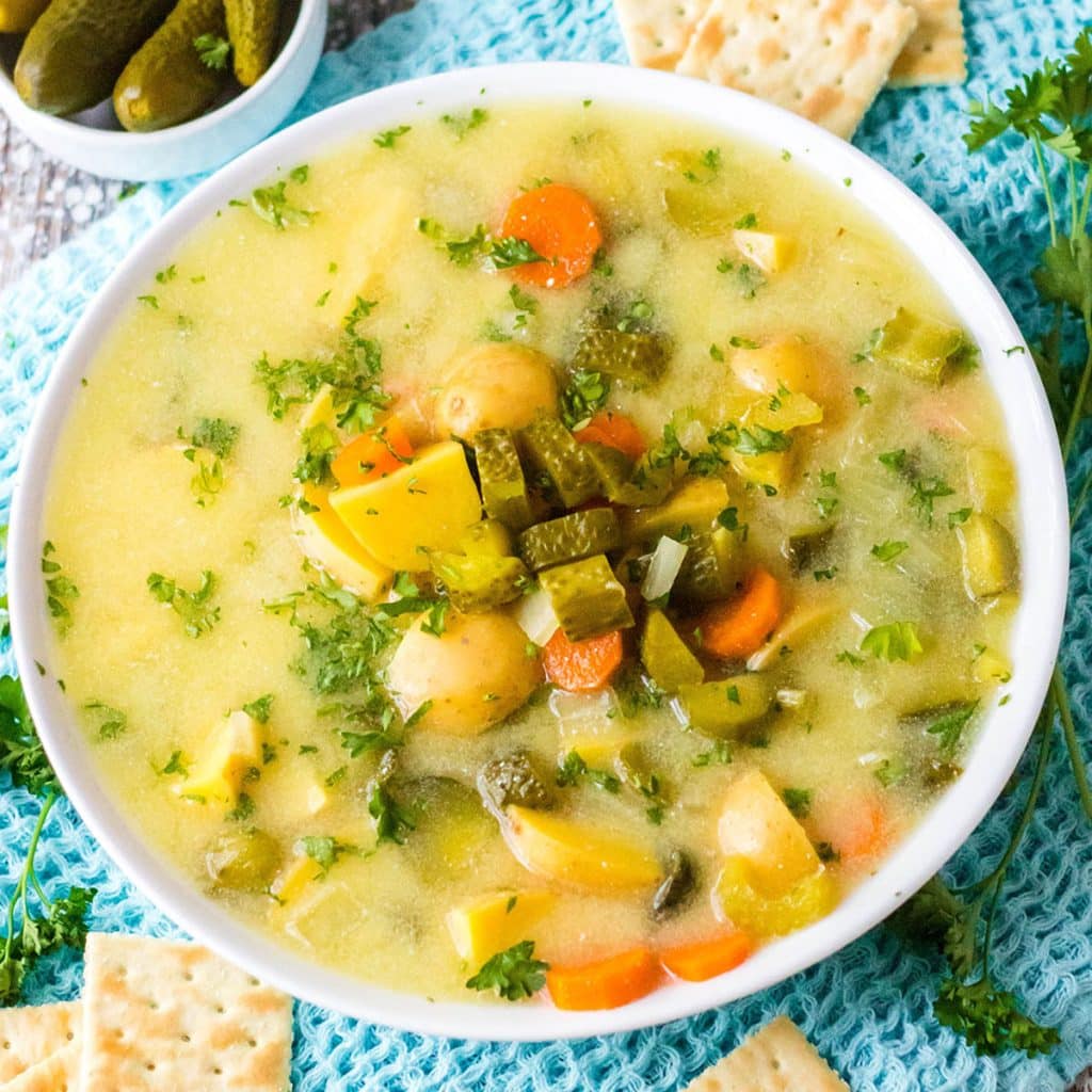 overhead shot of bowl of dill pickle soup in a white bowl.