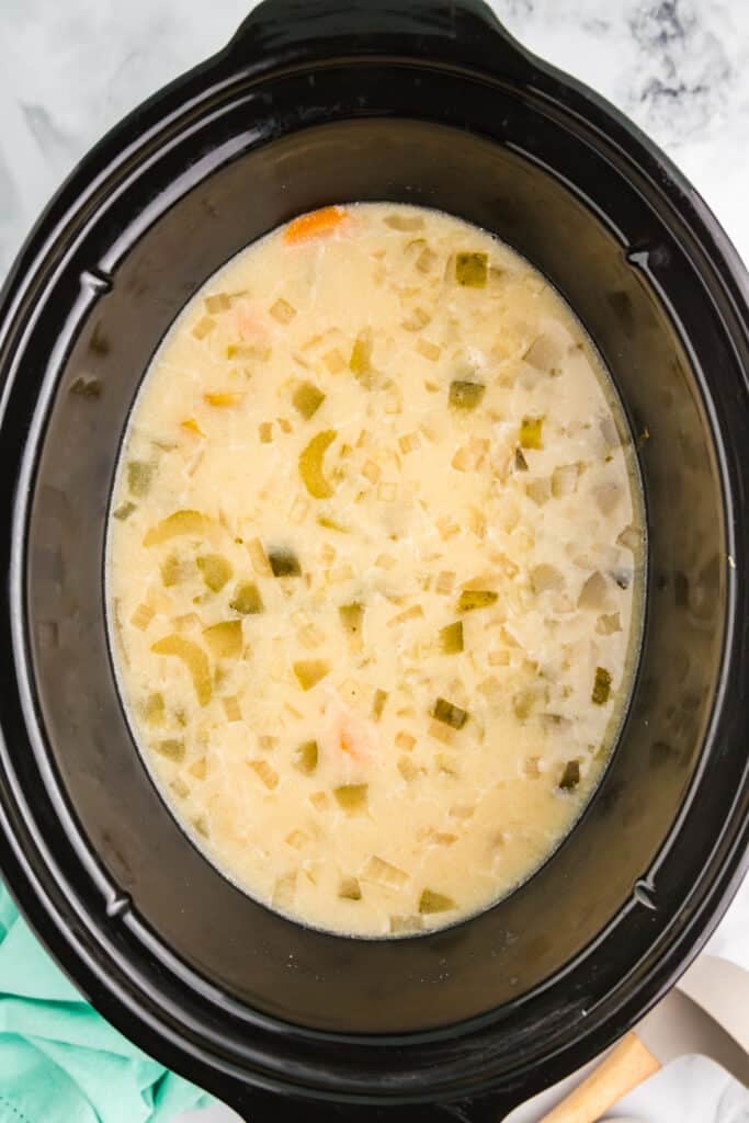 overhead shot of creamy dill pickle soup in a crockpot.