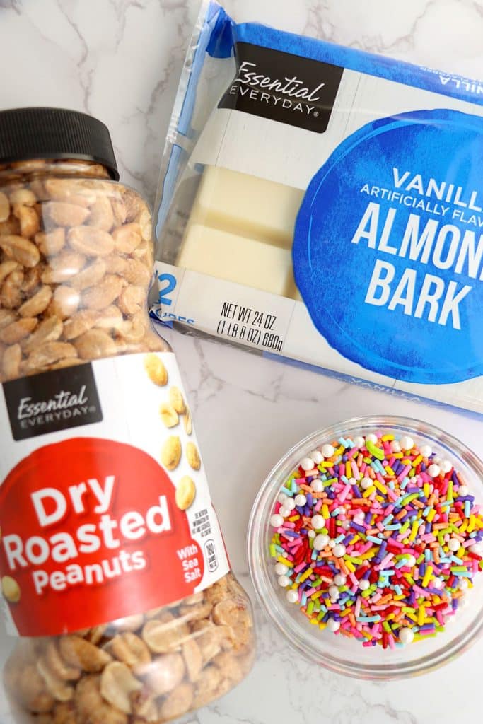 overhead shot of peanuts, almond bark, and sprinkles to make crockpot candy.