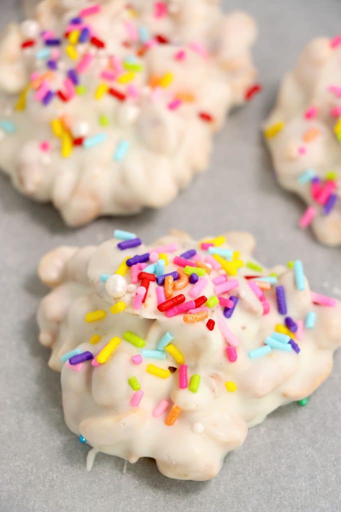 white chocolate peanut clusters with rainbow sprinkles.