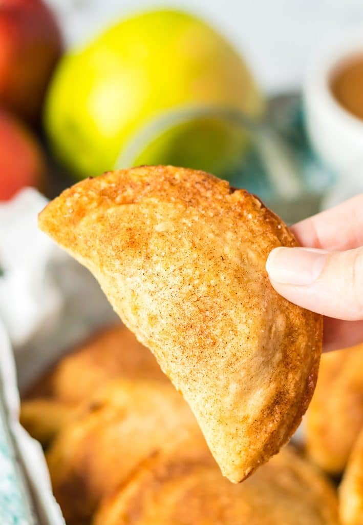 hand holding a caramel apple empanada.