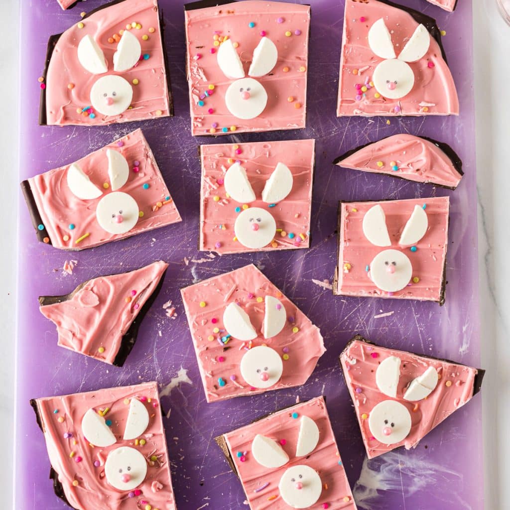 overhead shot of easter bunny candy bark on a purple cutting board.