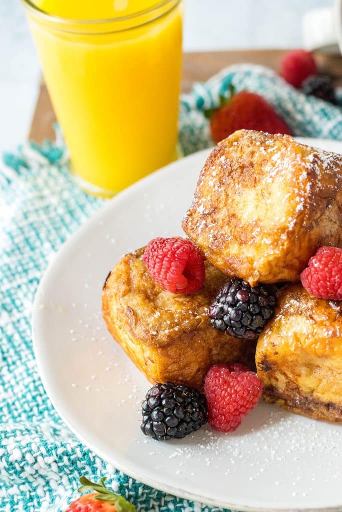 french toast with berries on a white plate.