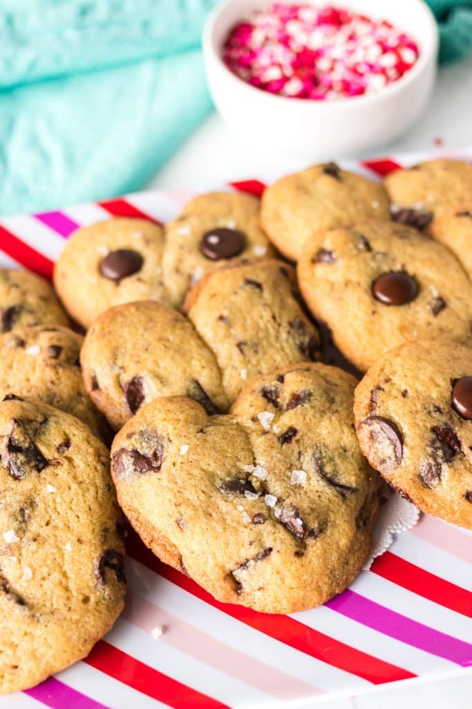 pink striped platter with heart shaped chocolate chip cookies.