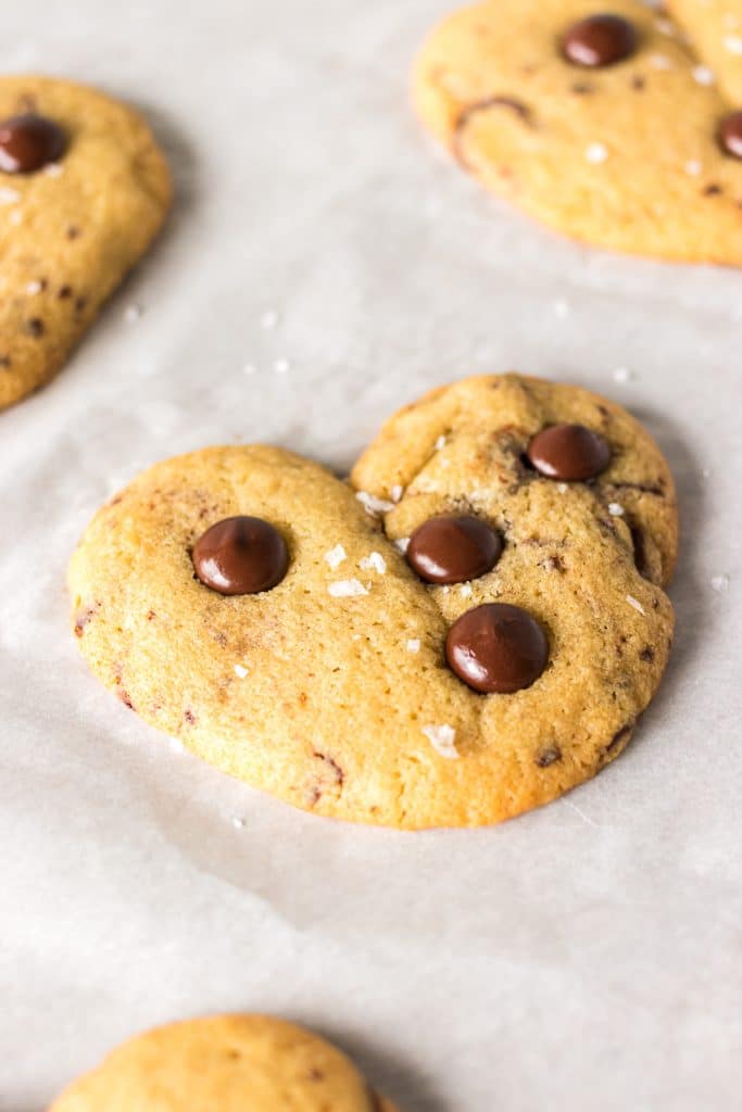heart shaped chocolate chip cookie on parchment paper.