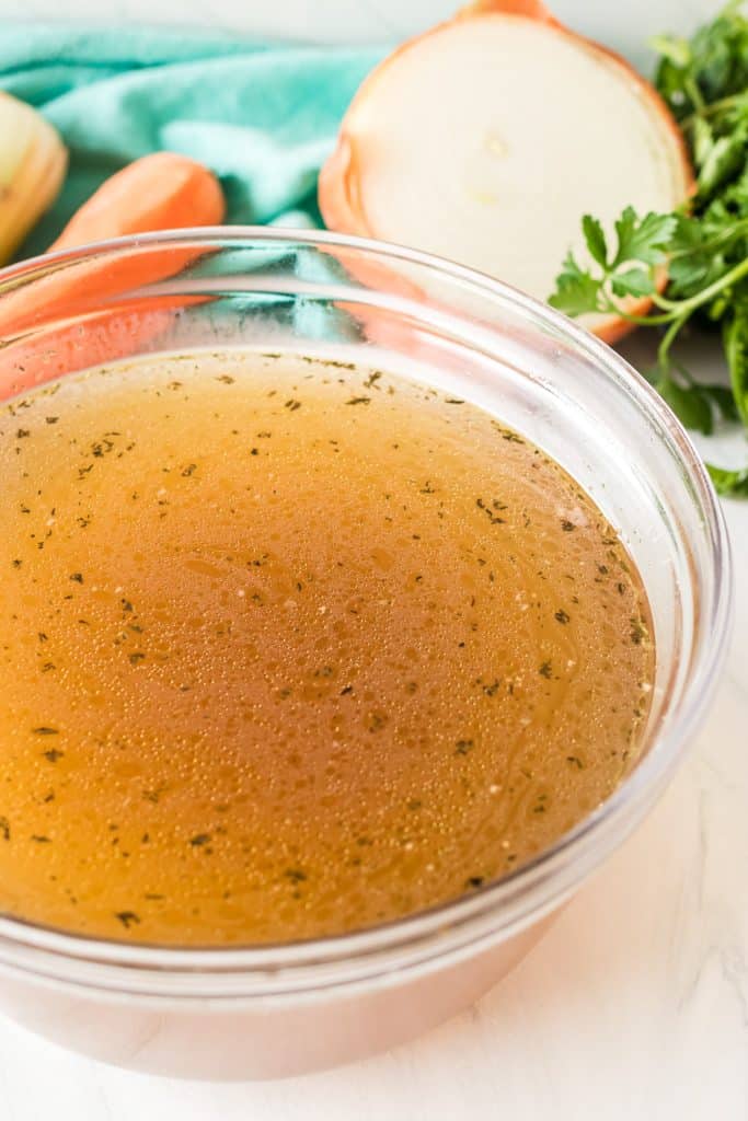 large glass bowl of homemade chicken stock.
