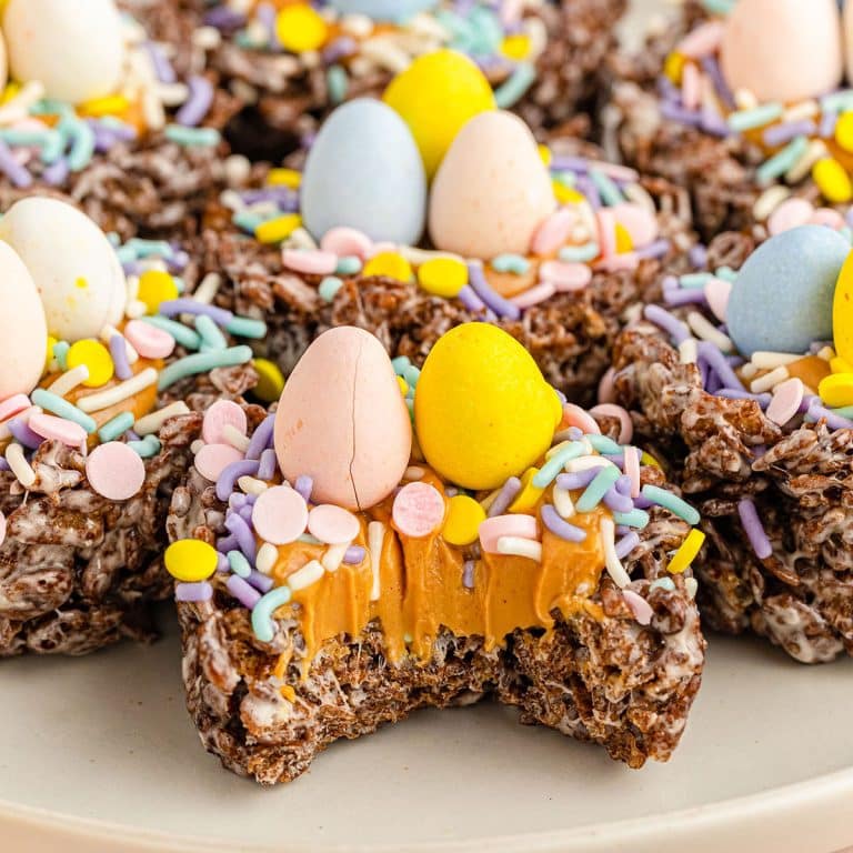 chocolate bird nest cookie with a bite missing showing the peanut butter filling.