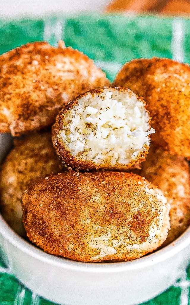 irish potato candy in a bowl with a bite missing showing the coconut center.