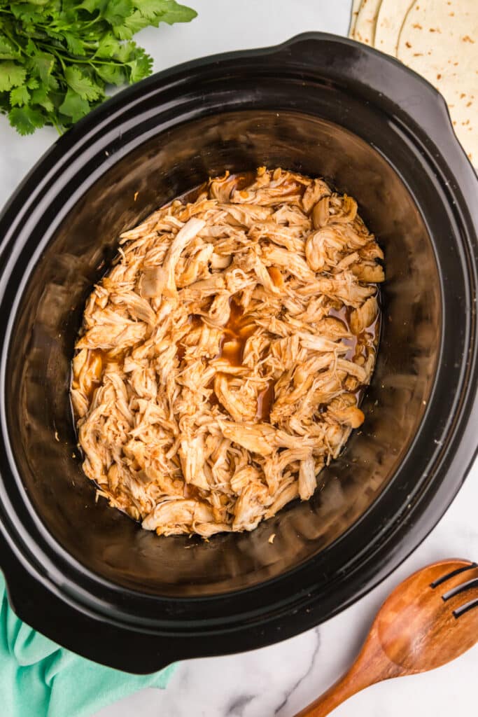 overhead shot of shredded honey lime chicken in a crockpot.