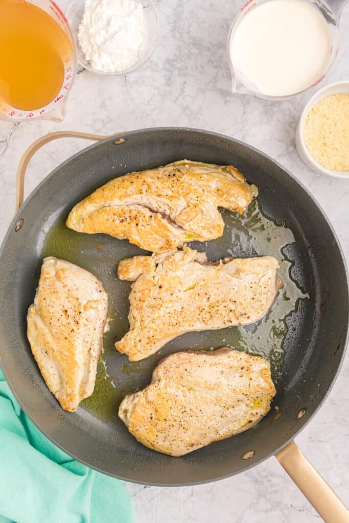 overhead shot of seared chicken breasts in a skillet.