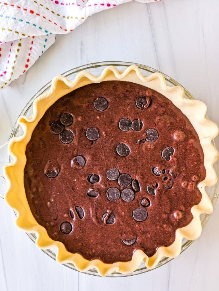 overhead shot of brownie batter in a pie crust.