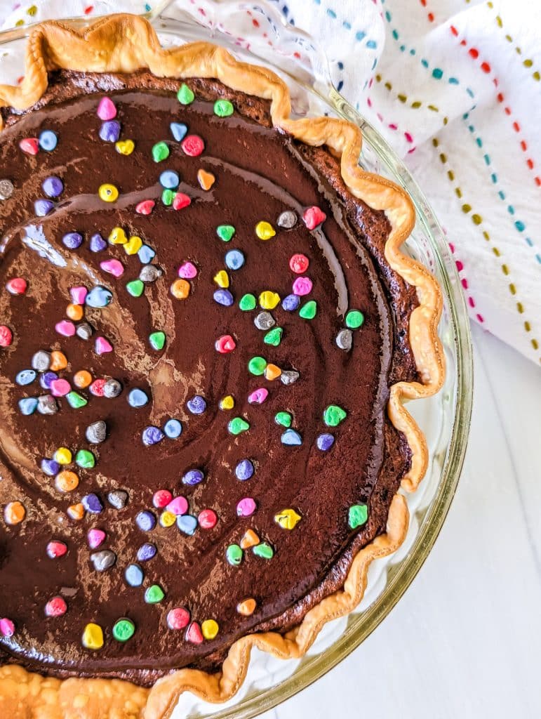 overhead shot of cosmic brownie pie topped with rainbow chips.